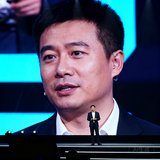 抖音体育运营负责人王涛在行业峰会演讲时的特写照片，背景是大型LED屏幕和深色舞台
